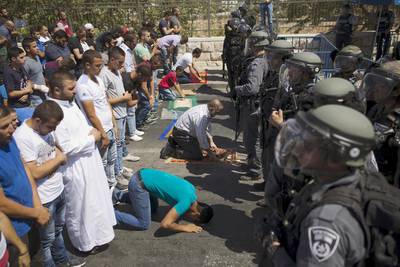 Palestinians who were barred entry from the Al Aqsa mosque were undeterred and resorted to praying outside the Old City's walls instead. Amir Cohen/Reuters