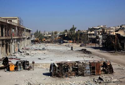 The carcass of a bus litters a bombed-out street in Ramussa on September 9, 2016, after pro-regime fighters took control of the strategically important district on the outskirts of the Syrian city of Aleppo yesterday. - The government advance in Ramussa has completely closed access routes into Aleppo's rebel-controlled east, under renewed siege by forces loyal to President Bashar al-Assad. (Photo by GEORGE OURFALIAN / AFP)