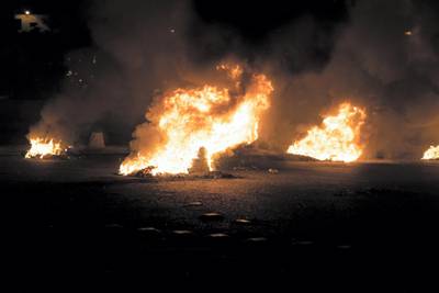 Protesters burn tyres and set up a roadblock on the Beirut-Saida motorway. William Lowry / The National
