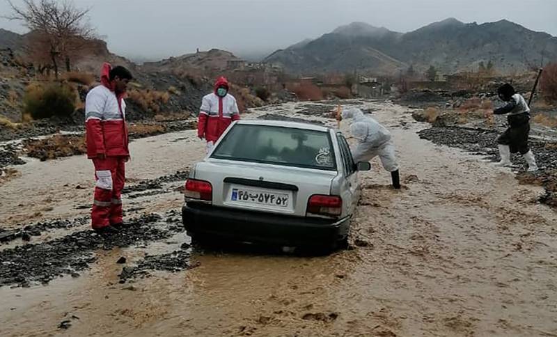 Red Crescent members assist a vehicle stuck in floods in the Hormozgan Province, south of Iran. AFP
