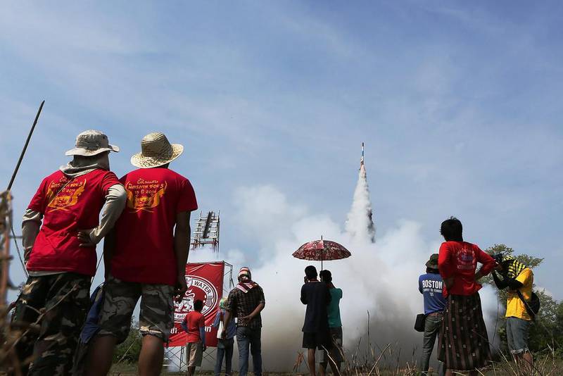 Yasothon resident look on as huge, handmade rockets are launched into the air during the Bun Bang Fai festival in Yasothon, Thailand. Taylor Weidman / Getty