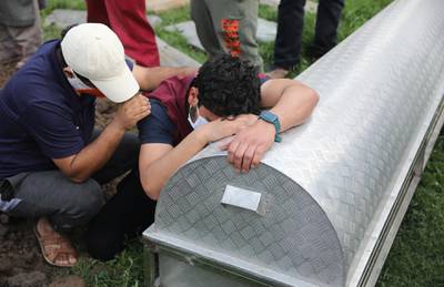 Kashmiris mourn over the coffin of a relative who died of Covid-19 at a graveyard on the outskirts of Srinagar. EPA