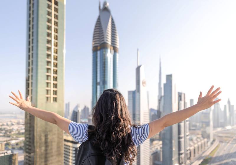 Tourists open their arms and look forward to the city of Dubai