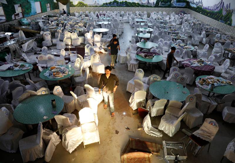 Workers inspect a damaged wedding hall after a blast in Kabul, Afghanistan. Reuters