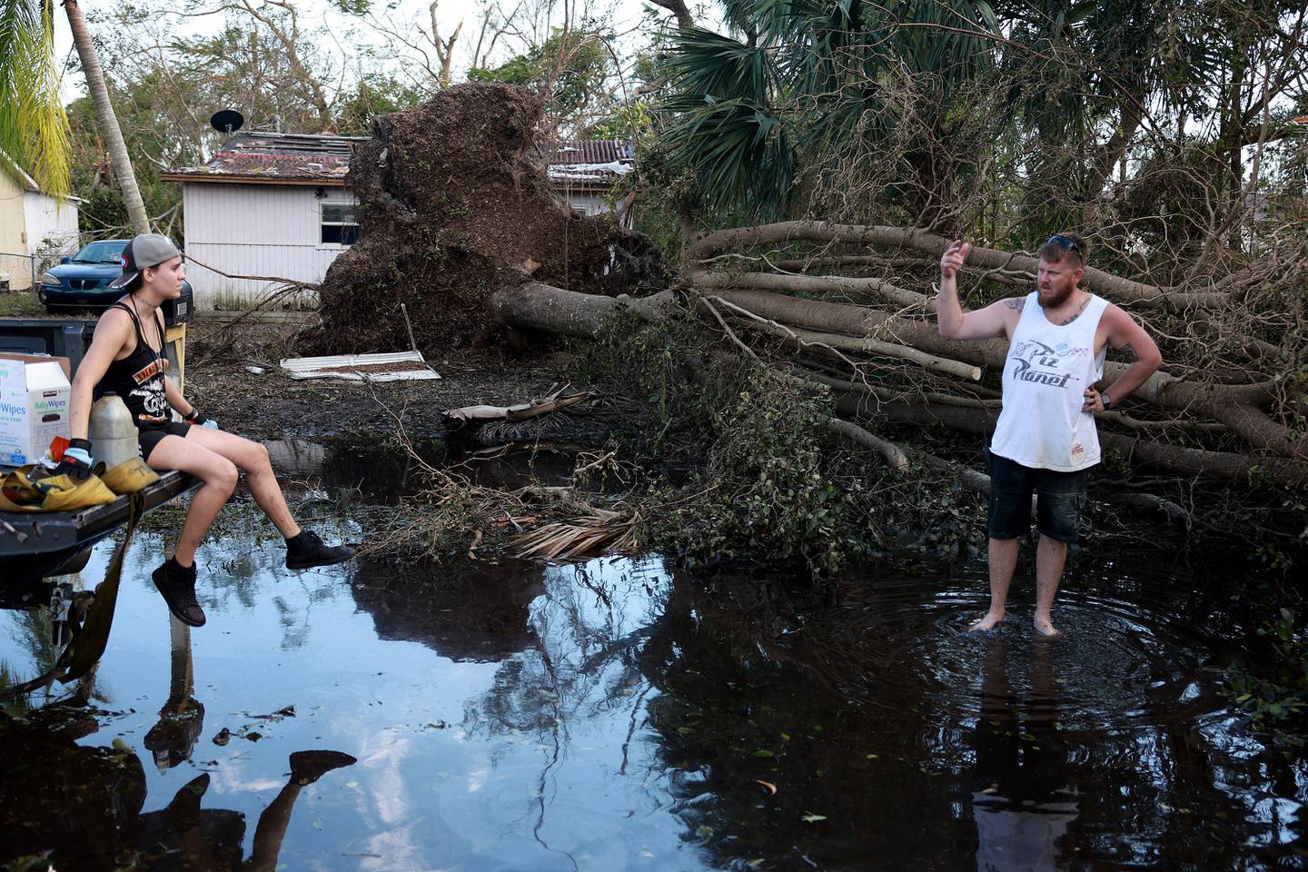 Wood work on clearing a tree from a road in Fort Myers, Florida, which was very badly hit by Ian. AFP
