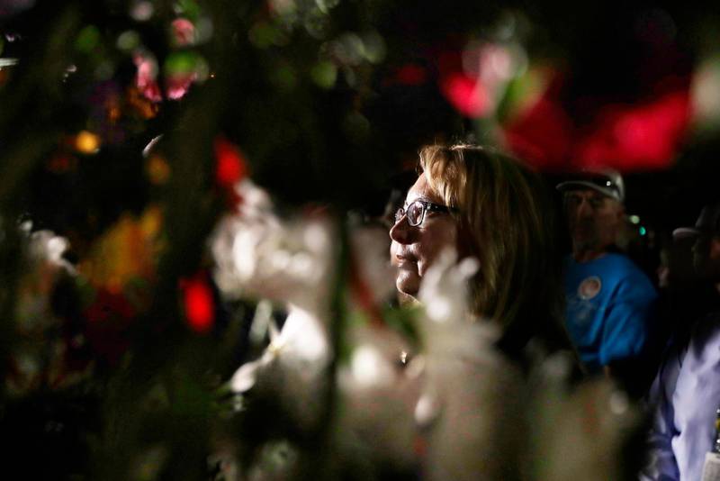 Former US Representative Gabby Giffords places a rose on a wall during the dedication of a healing garden. EPA