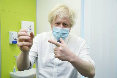 Britain's Prime Minister Boris Johnson holds a vial of AstraZeneca vaccine during a visit to a coronavirus vaccination centre in Orpington, South-East of London. Reuters