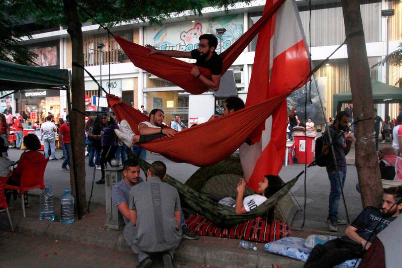 Lebanese protesters rest in hammocks during a demonstration in the southern Lebanese city of Sidon on the tenth day of country-wide protests against tax increases and official corruption. AFP