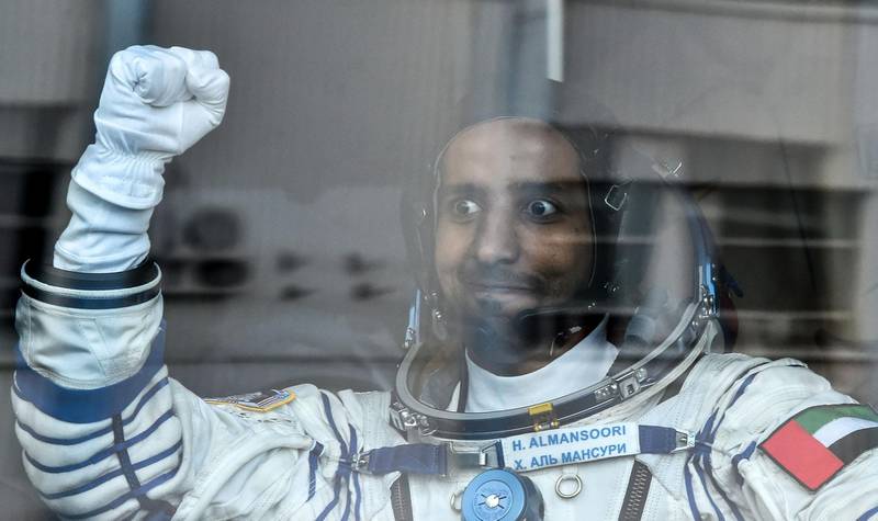 United Arab Emirates' astronaut Hazzaa al-Mansoori  raises his fist from a bus before boarding a Soyuz rocket to the International Space Station (ISS) at the Russian-leased Baikonur cosmodrome in Kazakhstan on September 25, 2019.  / AFP / VYACHESLAV OSELEDKO
