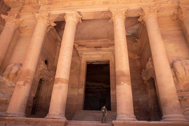 A worker cleans the stairs of the Treasury building at the reopened Petra archeological site, in Petra. EPA
