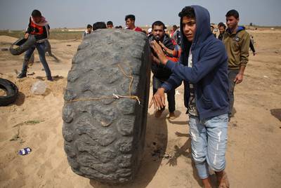 Palestinians prepare to burn tires during a protest at the border fence with Israel, east of Jabalia in the central Gaza city. Mohammed Abed / AFP Photo