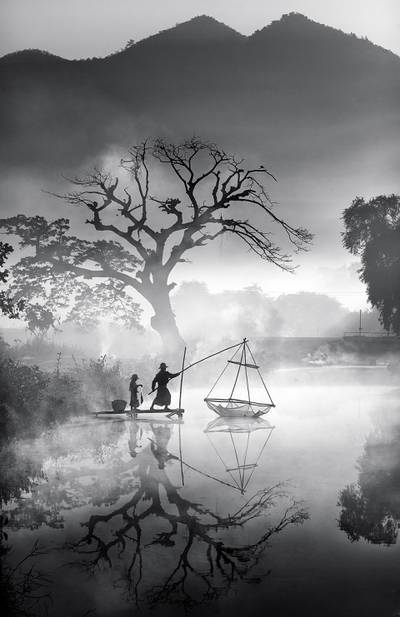 This scene shows a father and son catching fish early one winter morning. In Myanmar, children work with their parents to bring in an income for the whole family.
