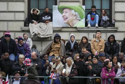 People waiting along the route that the coffin will be pulled on a gun carriage in central London. AP