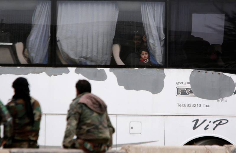 A boy looks through a bus window as rebels and civilians leave Harasta in eastern Ghouta, in Damascus, Syria on March 23, 2018. Omar Sanadiki / Reuters