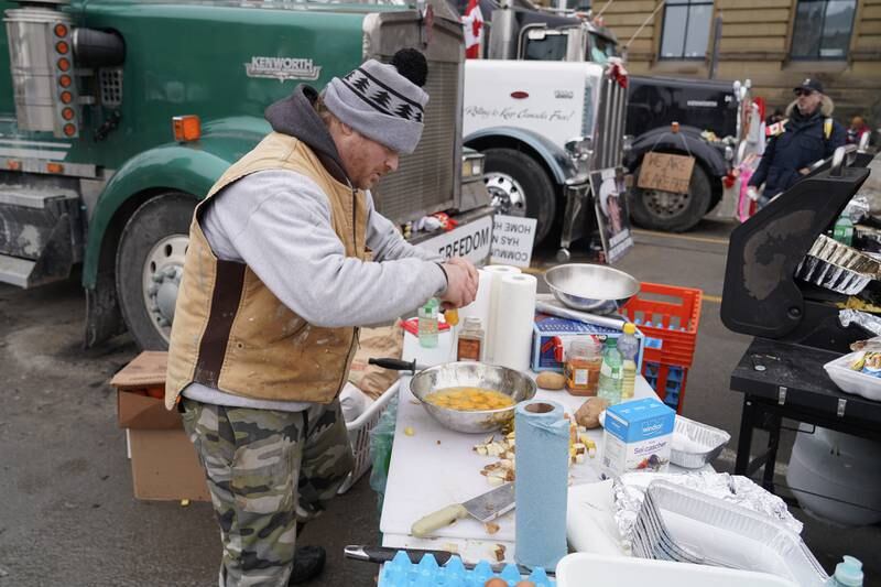 A man cracks an egg to help prepare food for the protesters. Willy Lowry / The National