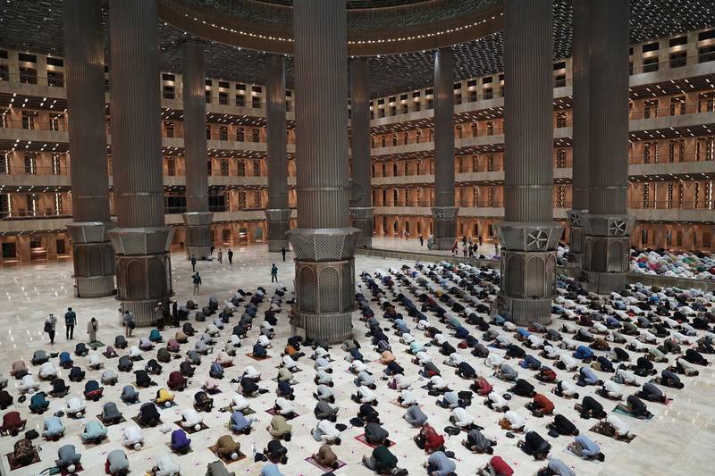 Worshippers perform taraweeh prayers while complying with physical-distancing rules at the Istiqlal Mosque in Jakarta, Indonesia. Bloomberg