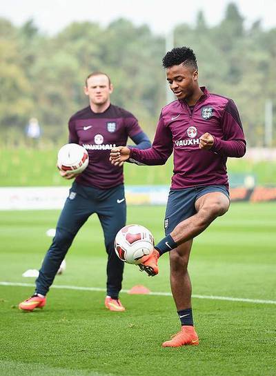 Wayne Rooney looks on as Raheem Sterling and other England teammates train ahead of the Euro 2016 qualifier against Switzerland. Laurence Griffiths / Getty Images