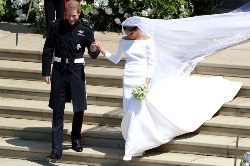 Prince Harry and his wife Meghan, who wore a dress by Clare Waight Keller with a hand-embroidered veil. AFP