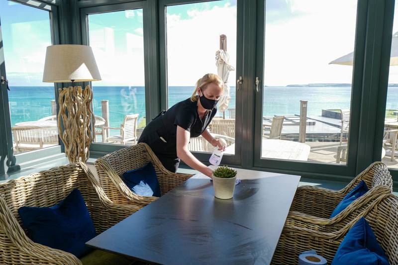 A member of the hotel staff cleans tables in the new orangery at the Carbis Bay Hotel. Getty Images