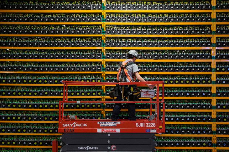 (FILES) In this file photo taken on March 19, 2018 A technician inspects the backside of bitcoin mining at Bitfarms in Saint Hyacinthe, Quebec on March 19, 2018. From its birth in an anonymous paper in 2008 to growth into one of the world's most volatile and closely watched financial instruments in 2018, bitcoin has lived through a tumultuous first 10 years. / AFP / Lars Hagberg
