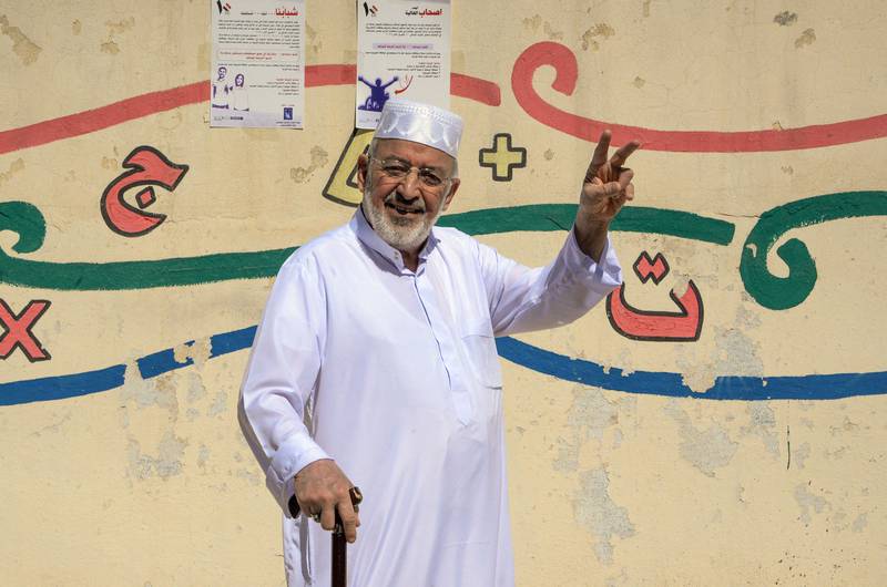 An Iraqi man flashes the V for victory sign as he arrives at a polling station at the southern city of Mosul, on October 10, 2021. AFP