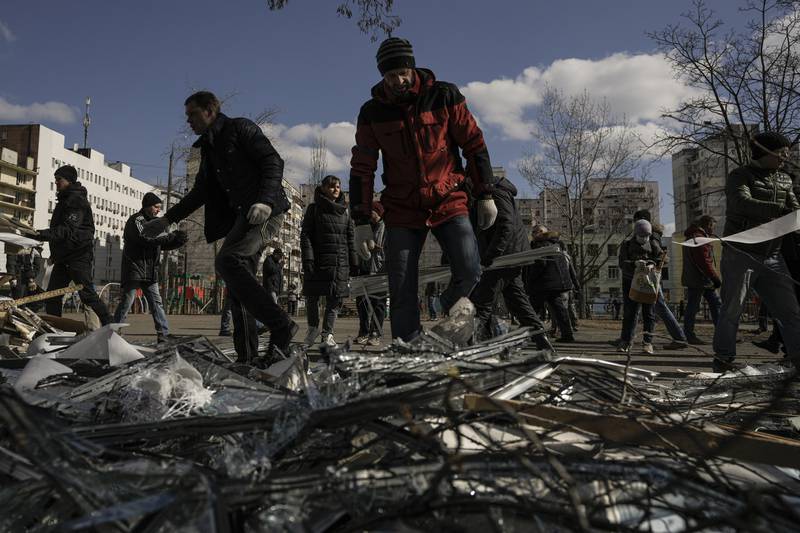 People clear debris outside a medical centre damaged by the same Russian missile after it was intercepted. AP