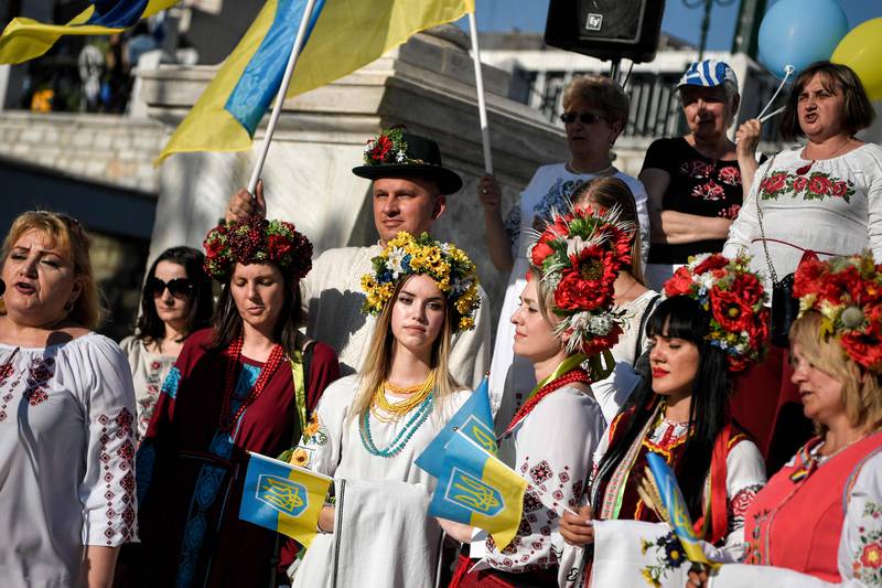 Ukrainians wearing traditional clothing listen to their national anthem as they take part in the celebration of 'Vyshyvanka Day', an annual celebration of Ukrainian folk traditions, in Athens. AFP