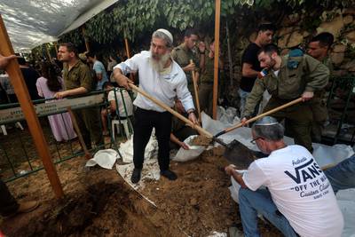 Israeli volunteers dig graves at Mount Herzl Military Cemetery in Jerusalem.  Reuters