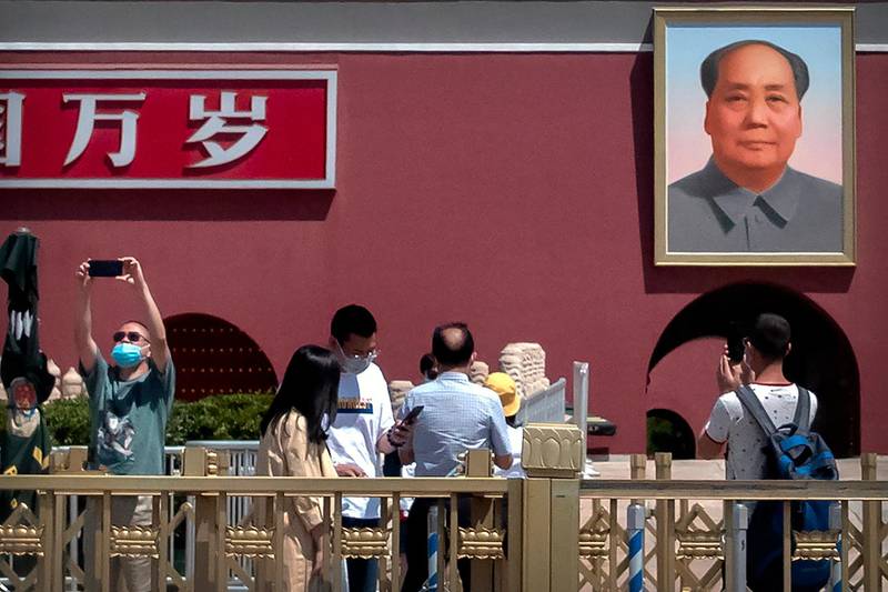 Visitors take photos near the portrait of Chinese leader Mao Zedong on Tiananmen Gate in Beijing. AP Photo