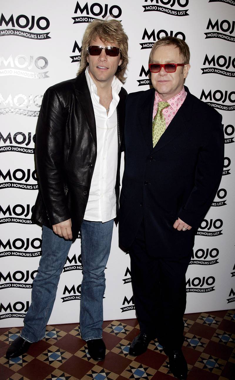 Jon Bon Jovi and Elton John, wearing a black shirt with a pink shirt and green tie, attend the Mojo Honours List awards at Shoreditch Town Hall, London on June 5, 2006. Getty Images