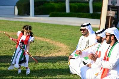 A girl dances to traditional Emirati music by Al Mazyood Band at a National Day event at Mohammed bin Rashid Library, next to Dubai Creek. All photos: Khushnum Bhandari / The National
