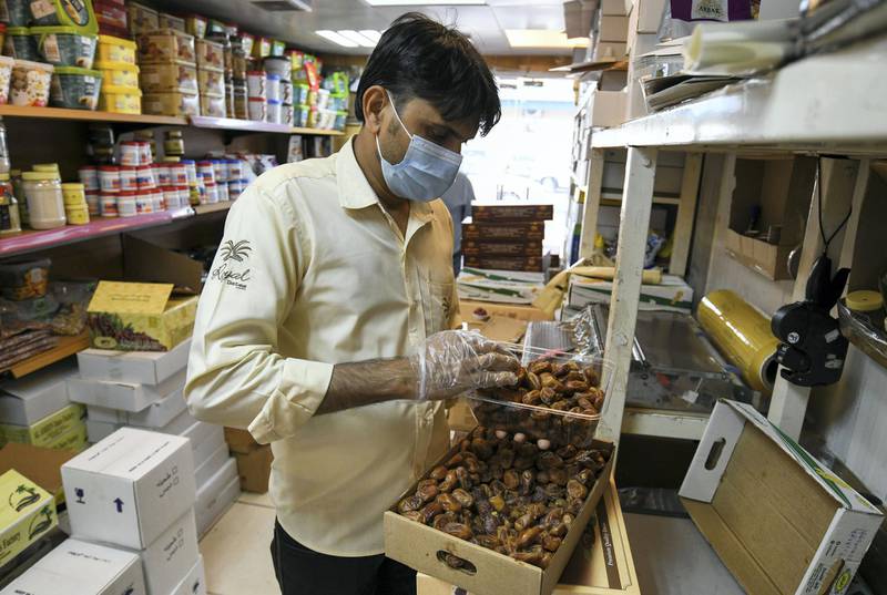 Abu Dhabi, United Arab Emirates - Hanif Suleiman packages several date boxes daily during Ramadan, at Royal Dates in the Mina market. Khushnum Bhandari for The National