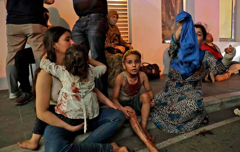 Wounded people wait to receive help outside a hospital following the explosion in Beirut. AFP