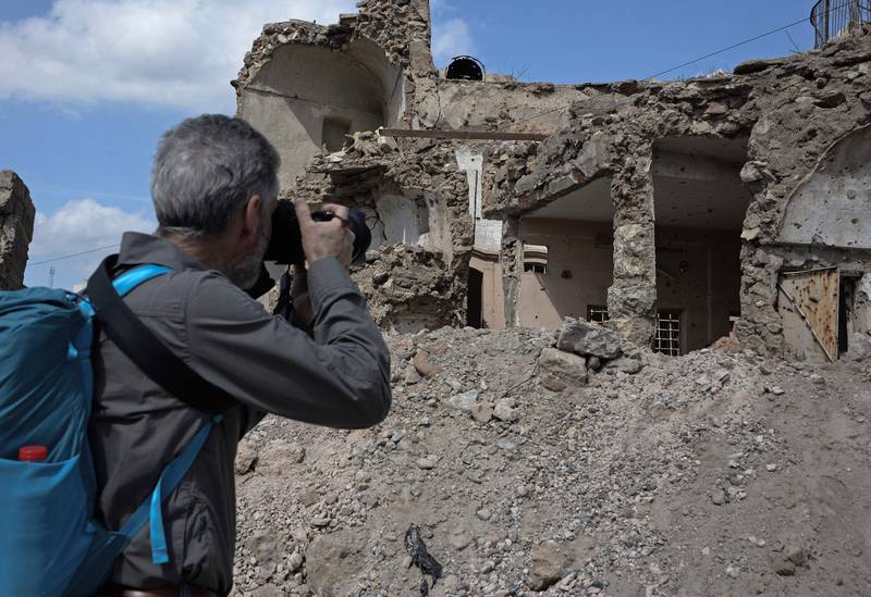 A tourist photographs the ruins left by years of conflict in the northern Iraqi city of Mosul. In June 2017, the Unesco listed Al Nuri Mosque, famed for its leaning minaret, was destroyed by ISIS occupiers.