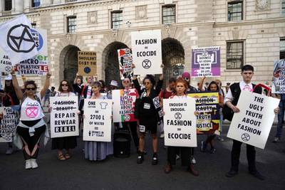 Protesters from Extinction Rebellion hold up anti-fashion placards as they block a road on the third day of London Fashion Week in London on September 15, 2019. / AFP / Niklas HALLE'N
