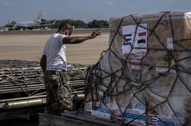 At Jose Marti International Airport in Havana, a ground crew member directs the loading of a shipment of Cuba developed and made coronavirus vaccines donated to Syria onto a cargo plane. Photo: AP