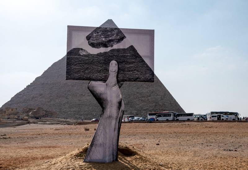 An installation titled 'Greetings From Giza' by French artist and photographer Jean Rene, better known as JR, at the ancient Giza Necropolis on October 23, 2021. AFP; Art D'Egypte