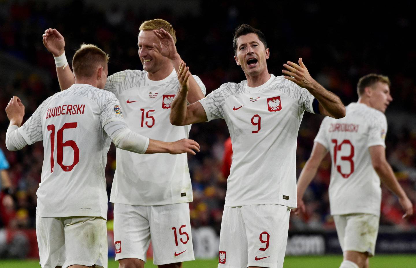 Poland's Karol Swiderski celebrates scoring with Kamil Glik and Robert Lewandowski. Reuters
