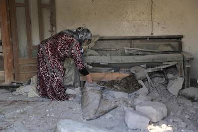 A woman checks damage to her home in the village of Barisha, in Idlib province, Syria. AP Photo
