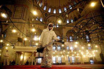 A worker in a protective suit disinfects the Fatih Mosque in Istanbul, Turkey. Reuters
