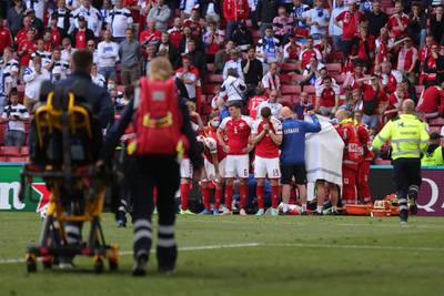 Denmark's players gather as paramedics attend to midfielder Christian Eriksen. AFP
