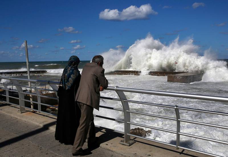 A couple watches the waves break at Fishers Marina sea wall, at the Corniche seaside, or waterfront promenade, in Beirut, Lebanon, Friday, Oct. 26, 2018. (AP Photo/Hussein Malla)