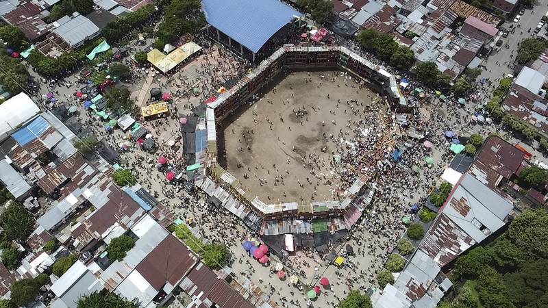 Spectators gather around wooden stands, which collapsed during a bullfight in Tolima state, Colombia. According to authorities, the collapse sent spectators plunging to the ground, killing several and injuring hundreds on June 26. AP