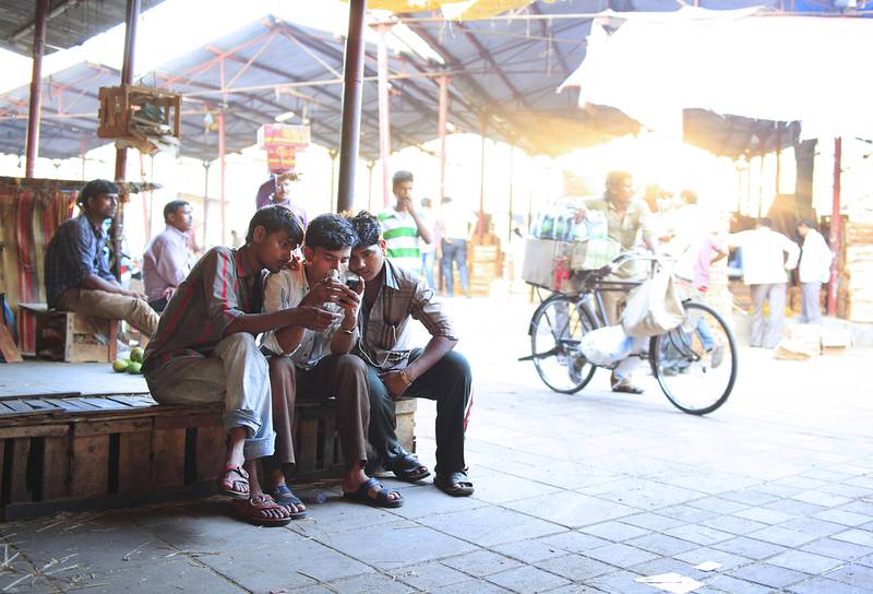 People check out television content on as smartphone at a market in Mumbai. Subhash Sharma / The National