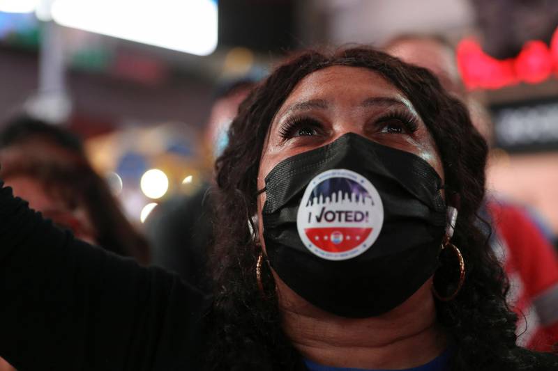 A woman reacts as she watches speeches by Joe Biden and Kamala Harris, in Times Square in New York City. Reuters