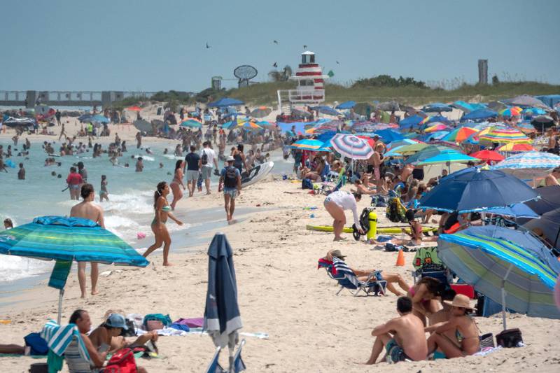 People enjoy a warm day at the beach in Miami Beach, Florida, US. Florida reported 15,300 coronavirus cases, on Sunday a record single-day surge anywhere in the US.  EPA