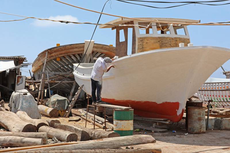 A worker paints a vessel at the family's boatyard.