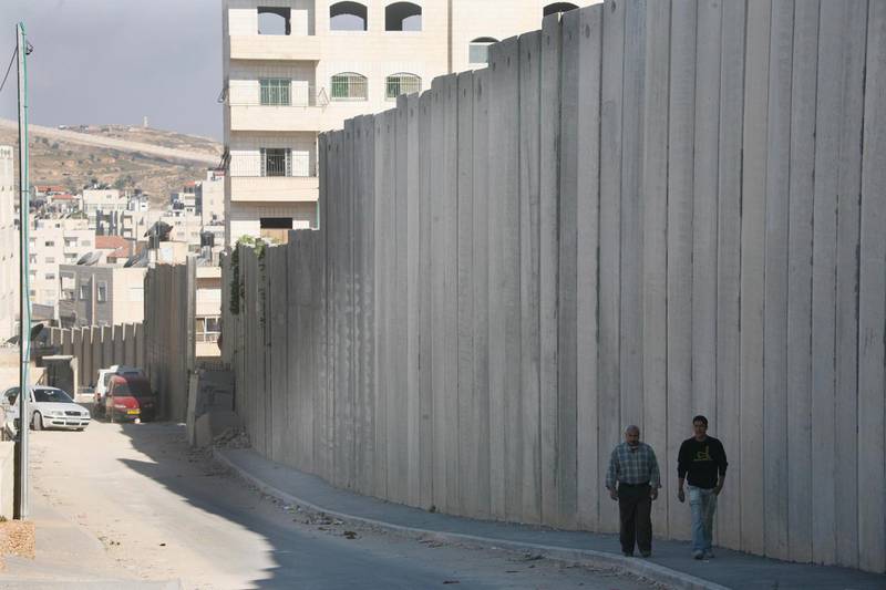 West Bank  - May 6th  ,  2008 - People walk through the  separation  barrier which runs through Alram  neighbourhood  of  Jerusalem ( Andrew Parsons  /  The National ) *** Local Caption *** ap013-0605-wall.jpg