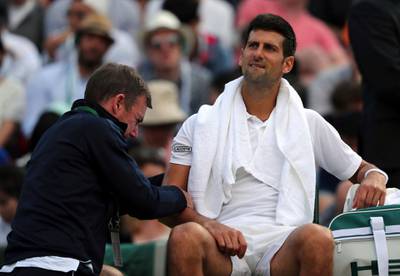 Serbia's Novak Djokovic receives medical treatment during his Men's Singles Match against Czech Republic's Tomas Berdych on day nine of the Wimbledon Tennis Championships at The All England Lawn Tennis and Croquet Club, London, Wednesday, July 12, 2017. (Gareth Fuller/PA via AP)