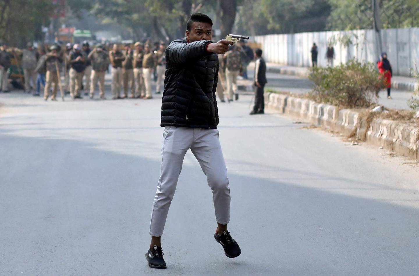 An unidentified man brandishes a gun during a protest against a new citizenship law outside the Jamia Millia Islamia university in New Delhi, India, 2020.
